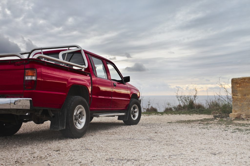 red-pickup-truck-parked-near-wall-937668